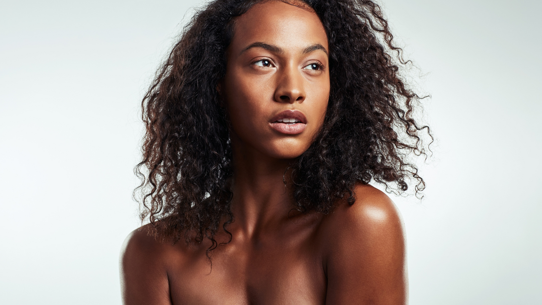 A close-up face portrait of a black woman smiling